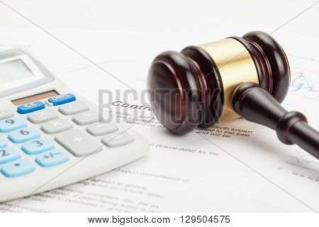 Wooden Judge's Gavel And Calculator Over Some Financial Documents