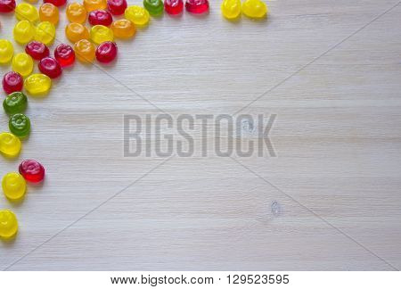 Colorful candy decoration frame over wooden white background