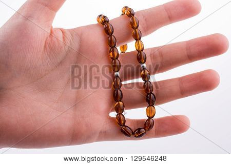 Hand holding a tespih on a white background