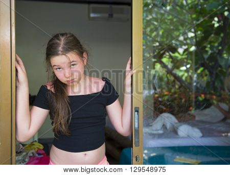 A sad little girl is standing on his doorstep