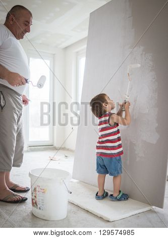 Little cute boy painting on a wall