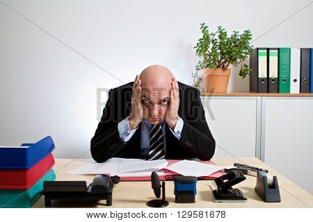 totally stressed manager. He holds his head with both hands