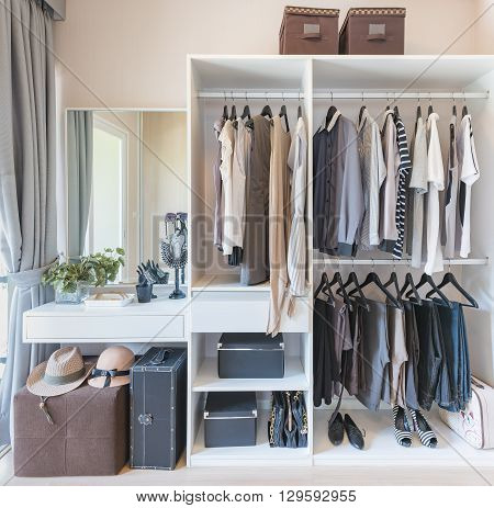 White Wardobe And Dressing Table With Clothes Hanging