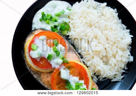Steak of Keta cooked with tomato, rice, onion and lemon . Delicious dish of keta