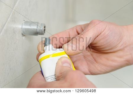 Plumber putting a paste sealant on the threads pipe.