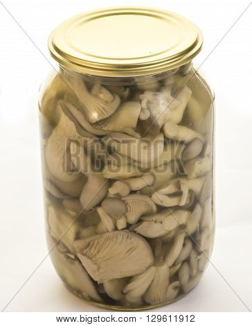 Jar with Marinovanymi mushrooms on a white background.