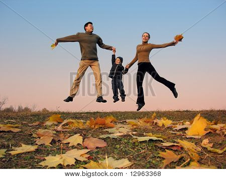 fly happy family with autumn leaves. color sunset sky