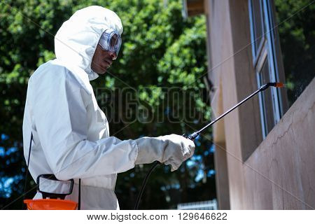 Man doing pest control in the backyard