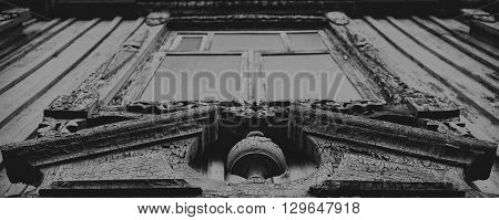 Grim window in old wooden house. Upview.
