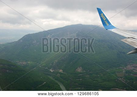 GENEVE AIRPORT SWITZERLAND ALPES - APRIL 28 2015: An Aircraft operated by UIA (Ukraine International Airlines) flying between Alpes mountains before landing in Geneve airport