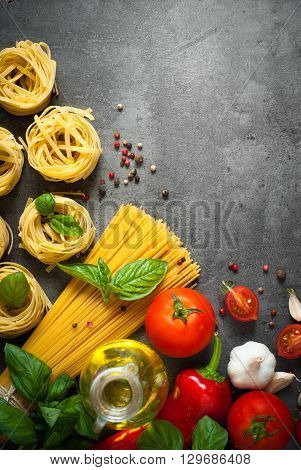 Ingredients for cooking Italian pasta - spaghetti tomatoes basil and garlic. Top view with space for taxt.