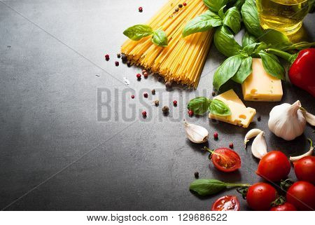 Ingredients for cooking Italian pasta - spaghetti tomatoes basil and garlic. Top view with space for taxt.
