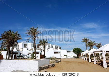 HERAKLION CRETE GREECE - MAY 13 2014: The blue sky modern buildings of villas and palms on the terrain of luxury class hotel on the Mediterranean coast of Crete May 13 2014 Greece.