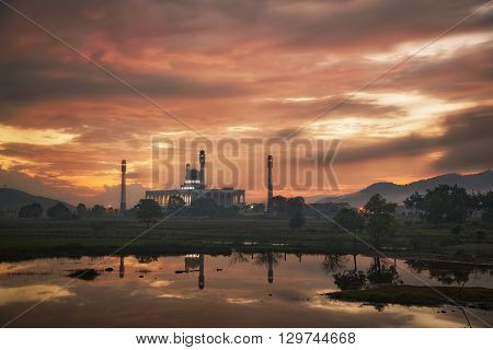 Beautiful mosque on green field with sunrise and reflection