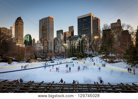 Winter scene in Central Park: the Wollman Rink at sunset with Manhattan Midtown skyscrapers. New York City