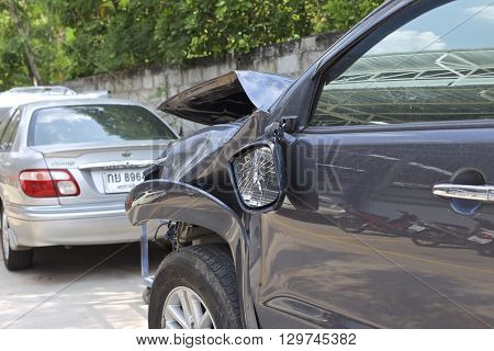 A wrecked car lays in wait after a vicious car accident. Rescue workers linger in the background.