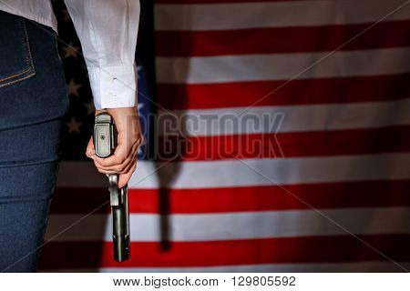 Woman holding handgun on USA national flag background