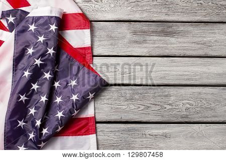 Creased national flag of USA. Bright flag on wooden background. Unity means strength. Honor and patriotism.