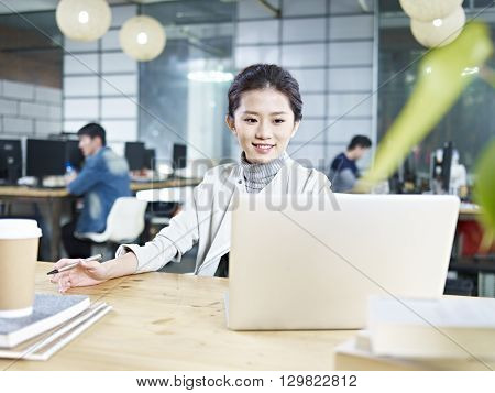 young asian business woman working in office using laptop computer.