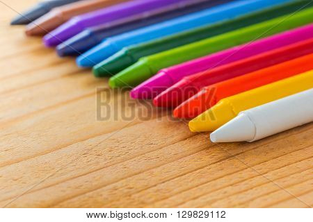 A photo of colorful crayon color on wood texture Selective focus