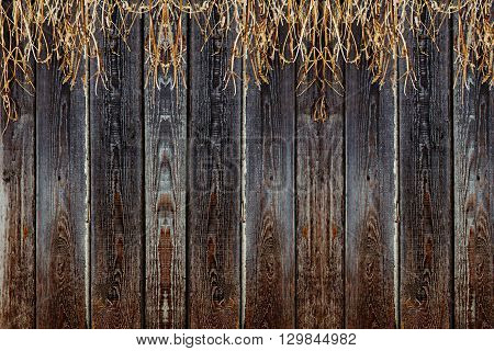 Old wooden fence. Vintage boards and dry grass. Wooden background. Wooden texture.