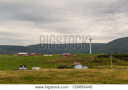 CAPE BRETON CANADA - 27TH AUGUST 2014: Buildings hills and a wind turbine in Cape Breton Nova Scotia during the day