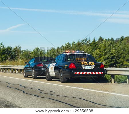 CANADA - 29TH AUGUST 2014: A car that has been pulled over by the police on a road in Canada.