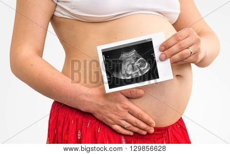 Belly of a pregnant woman and ultrasound with baby isolated on white background