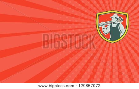 Business card showing illustration of a mechanic holding spanner on shoulder looking to the side set inside shield crest on isolated background done in retro style.