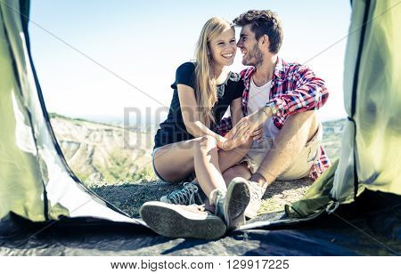 Happy couple having fun on camping. Couple sitting out thei tent and sharing happy moments