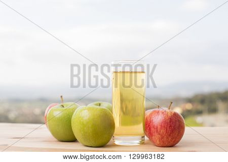 apples and apple juice on a wooden table, outdoor