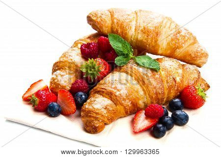 Fresh tasty croissants with berries on white background