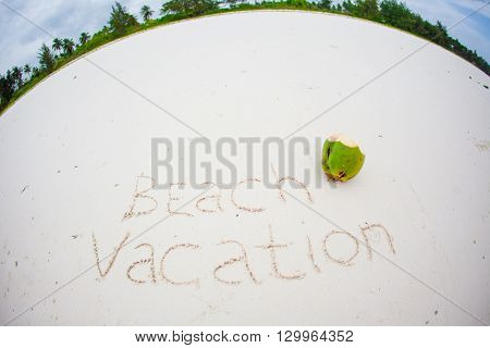 Beach vacation note written on white sandy beach