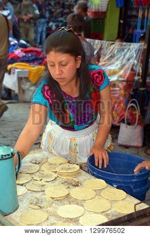 CHICHICASTENANGO GUSTEMALA APRIL 29 2016: Woman cooking tortillas in the Chichicastenango Market. This native market is the most colorful in Central America