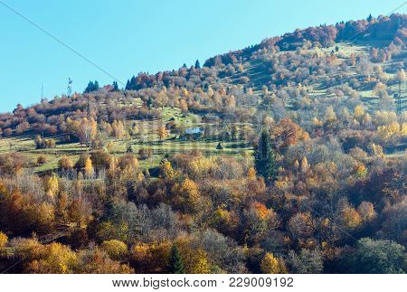 Autumn Carpathian Mountains Landscape With Multicolored Trees And Mountain Village Outskirts On Slop