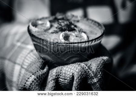 A Human Hand Holding Hot Bitter Gourd Smoothie With An Towel.