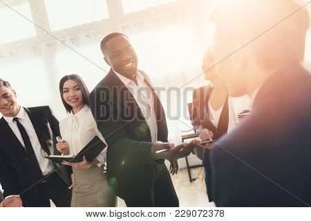 A Group Of Young People Holds Brainstorming In The Office. They Work In A Call Center And Discuss Bu