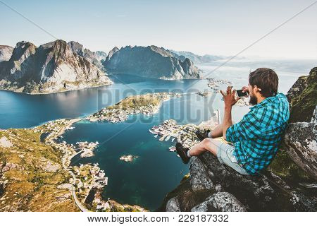 Man Tourist Using Smartphone On Cliff Travel Lifestyle Concept Adventure Outdoor In Norway Reinebrin