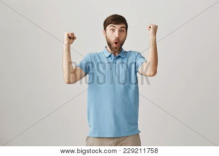 Portrait Of Positive Good-looking Slim European Bearded Man, Standing Over Gray Background With Rais