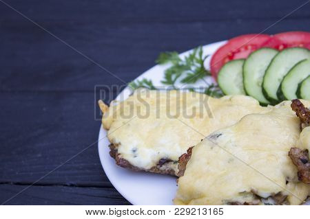 Steak With Vegetables On A Black Wooden Background
