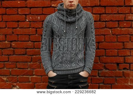 Fashionable Knitted Vintage Gray Sweater. Body Man In A Stylish Knitted Pullover Near A Red Brick Wa