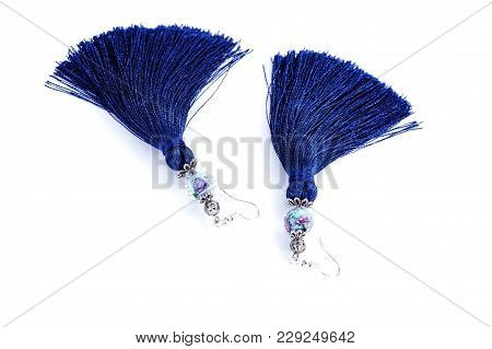 Blue Handmade Tassel Earrings On A White Background.