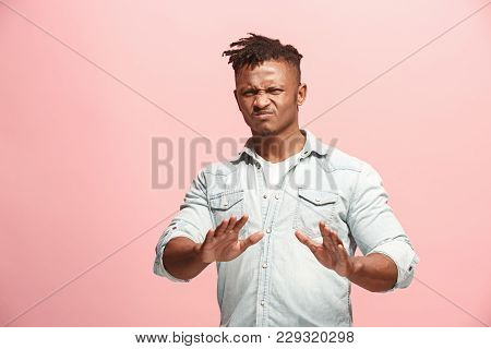 Young Man With Disgusted Expression Repulsing Something, Isolated On The Pink