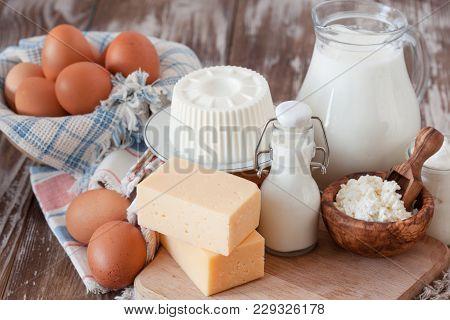 Set Of Different Milk Products On Ristic Wooden Table