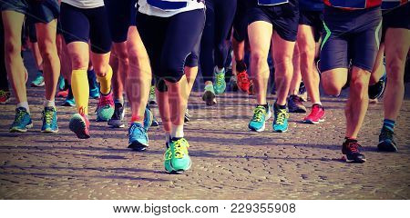 Group Of Runners On The Finish Line Of An Exciting Marathon Race Through The Streets Of The City Wit