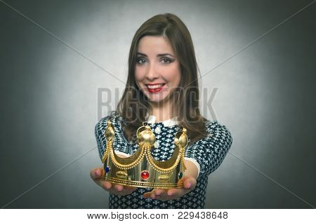 Happy Woman Is Stretching Ahead A Gold Crown Isolated On Gray Background. Award Ceremony. Transfer O
