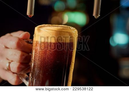 Bartender Hand Pouring Fresh Beer. Close Up Barman Hand At Beer Tap Pouring Beverage In Glass. Pouri