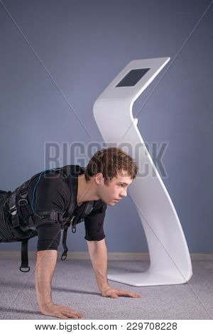Man In Ems Suits Doing Plank Exercise. Workout.