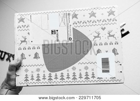 Paris, France - Jan 1, 2018: Man Holding Against White Background A Box Containing Fashion Clothes B