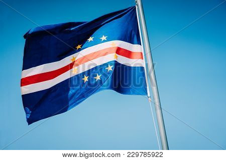 Cape Verde Flag Waving On The Mast With Blue Sky Background.